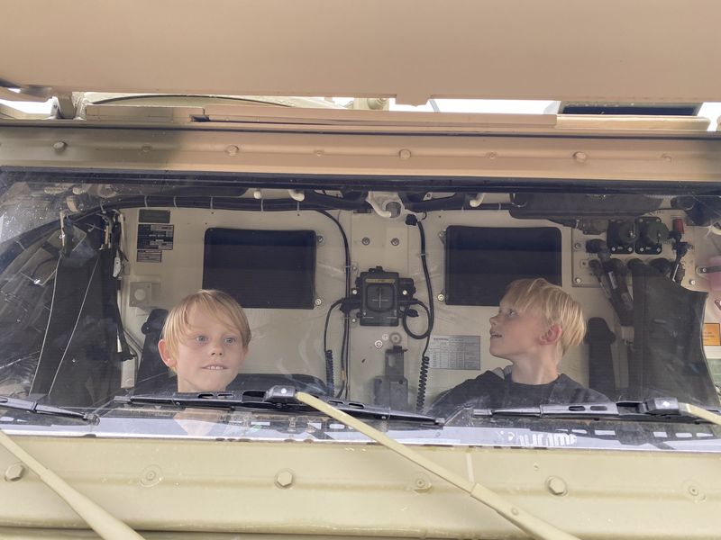 Two children looking out of the cab of a Bundeswehr vehicle