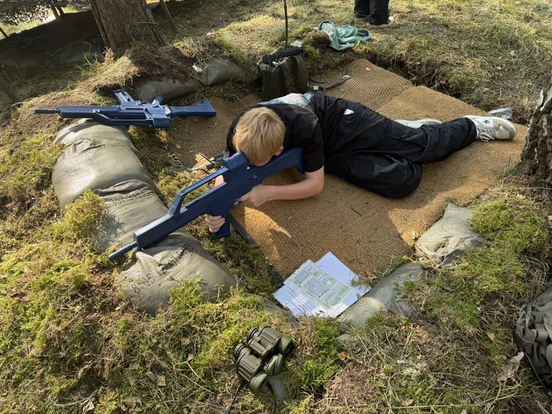 Child at a hands-on station with blue training kit in a sand hollow