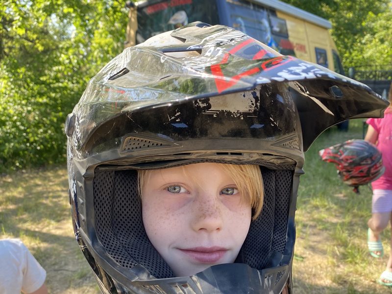 Kind blickt aus einem Motocrosshelm