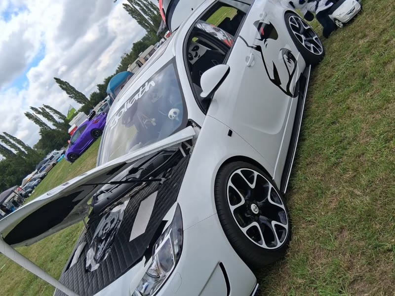 Weißer Opel mit Panda-Folie und offener Motorhaube
