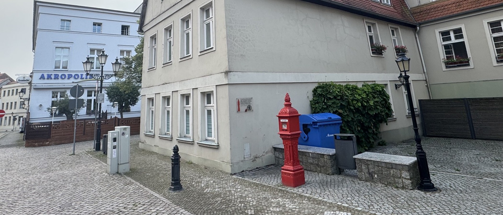 Roter historischer Feuermelder vor den Häusern an der Nordseite des Rathauses in Havelberg