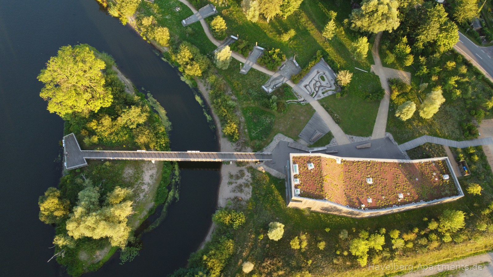 Luftaufnahme Haus der Flüsse mit begrüntem Dach und Steg zur Petroleuminsel