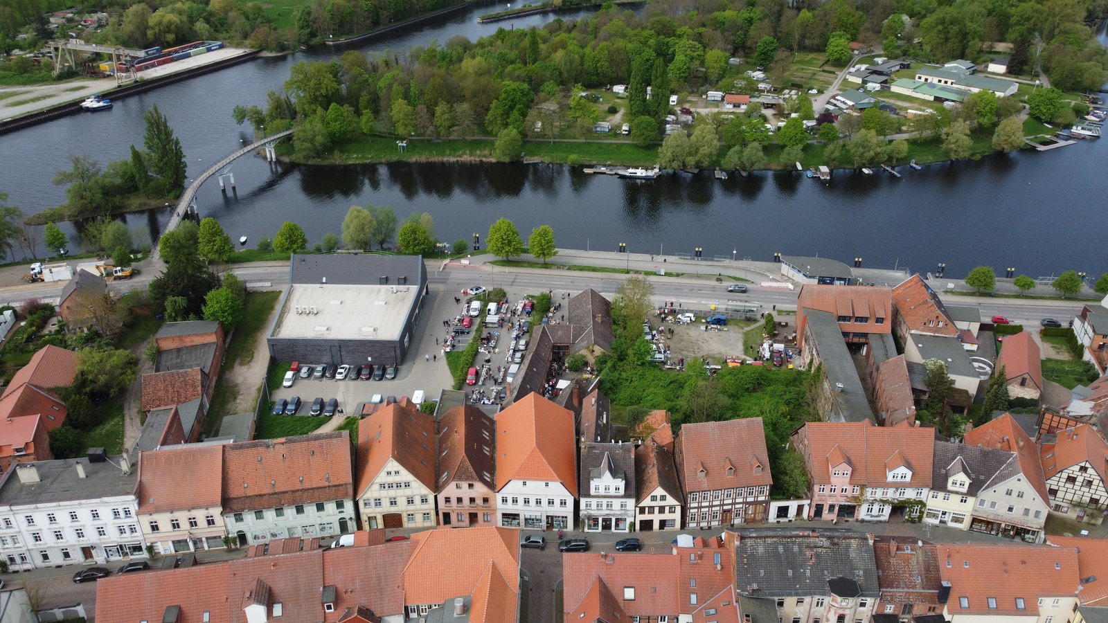 Drohnenaufnahme 2024: Lange Straße Havelberg im Vordergrund, Uferstraße mit Rossmann, Winterhafen und Havelstegbrücke zur Campinginsel
