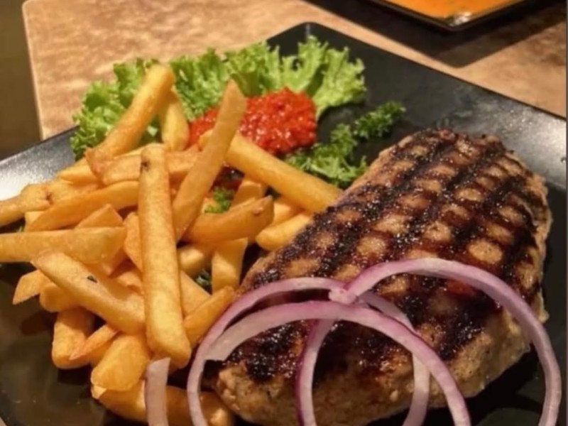 Gegrilltes Fleisch mit Pommes und Zwiebelringen