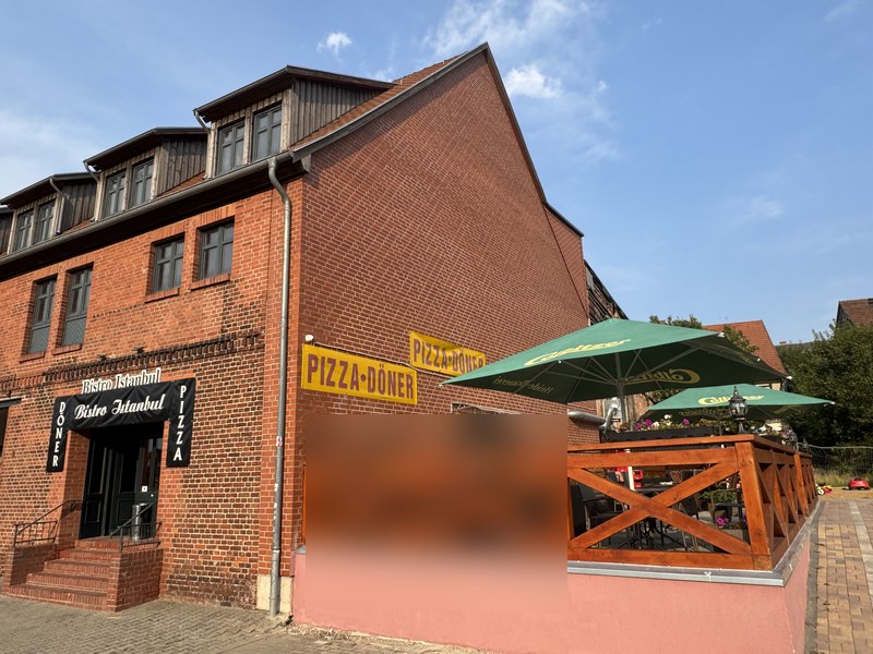Terrasse mit Holzgeländer und grünen Schirmen