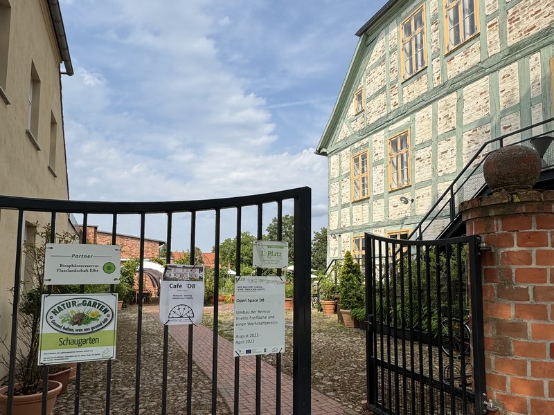 Hofeingang Café D8 mit Schildern Naturgarten und Café