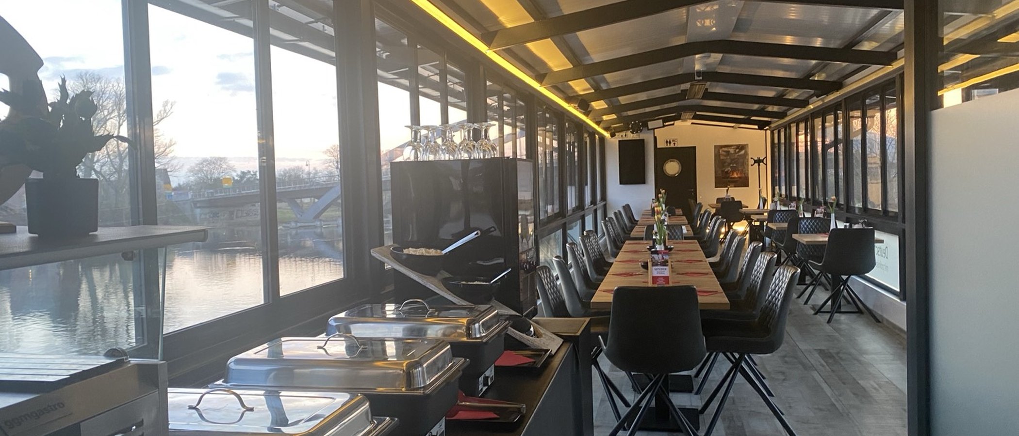 Langer Gastraum des Restaurantschiffs Hoffnung mit Glasfront zur Havel