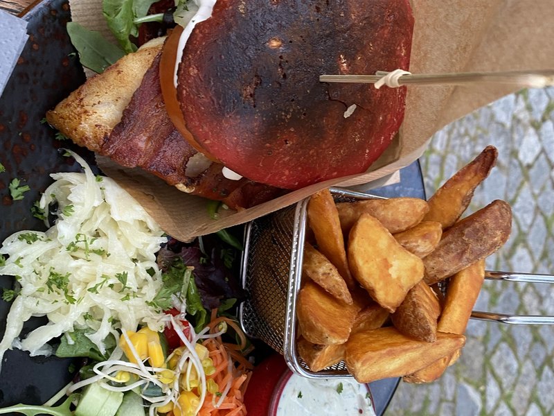 Fischburger im roten Brötchen mit Salat und Pommes