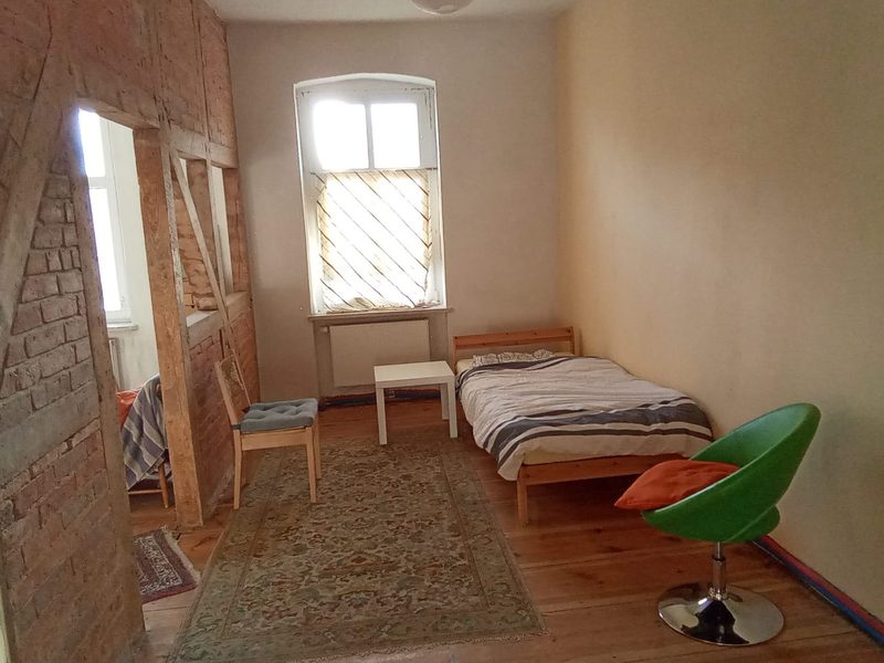 Schlafzimmer mit Bett unter dem Fenster, Ferienwohnung Galerie Stadtinsel