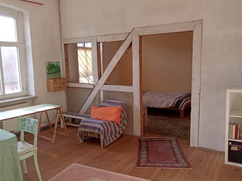 Wohnraum mit sichtbarem Fachwerk und Blick ins Schlafzimmer, Galerie Stadtinsel