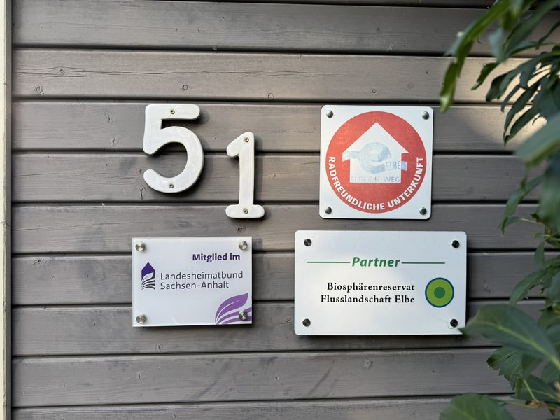 Hausnummer 51 und Schilder Radfreundliche Unterkunft, Landesheimatbund und Biosphärenreservat